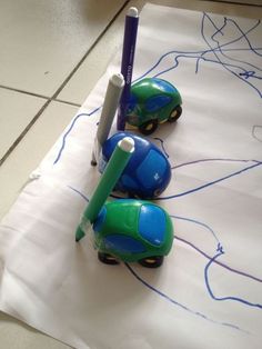 three toy cars sitting on top of a piece of white paper with blue writing on it