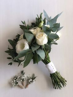 a bridal bouquet with white roses and greenery