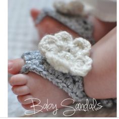 a baby's foot with a crocheted flower on it and the words baby sandals written in white