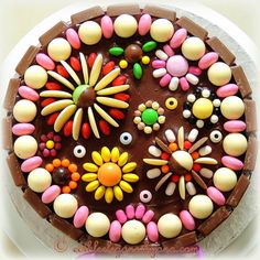 a chocolate cake decorated with colorful candies and flowers