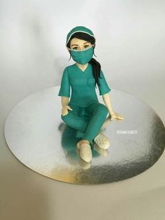 a cake that looks like a woman in scrubs sitting on a round table with her legs crossed