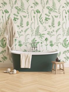 a bath tub sitting next to a wall with green plants on the wall and floor