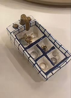 an assortment of rings in a blue and white tray