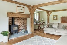 a living room filled with furniture and a fire place next to a brick wall in front of a fireplace