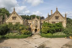 an old building with hedges and trees around it