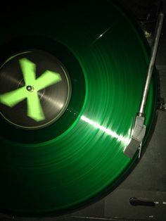 a green record player with the letter k on it's side and a black background