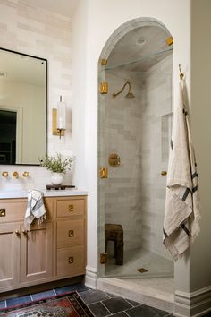 a bathroom with a walk in shower sitting next to a sink and a large mirror