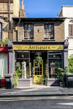 an old fashion store on the corner of a street in front of tall brick buildings