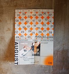 an orange and white calendar is hanging on the wall next to a pair of scissors