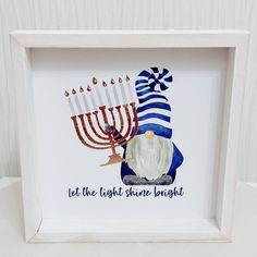 a white frame with a lit menorah and the words let the light shine bright