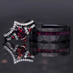 two wedding bands with red and white stones on them, one has a star shaped diamond in the middle