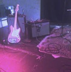 two guitars and amps are sitting on the floor