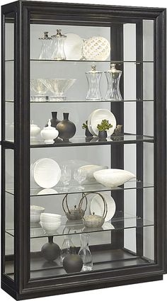 a display case filled with lots of different types of vases and dishes on top of glass shelves