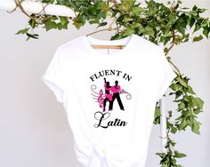 "Here is a fantastic dancer's t-shirt that would be perfect for the latin dancer in your life.  It reads \"Fluent in Latin\" and has an image of latin dancers mid pose in silhouette with the features picked out in fluorescent pink although I can make this in different colours so can make this a beautiful dance gift which can be bespoke to your requirements. Graphics are adhered to each shirt using a heat transfer process for durability and long-lasting wear.  To specify your item size, choose fr Salsa Dancer, Dance T Shirt, Beautiful Dance, Dance Gifts, Latin Dance, Heat Transfer, Bespoke, Inside Out, Dancer