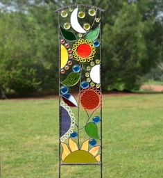 a tall stained glass sun catcher in the grass