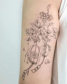 a woman's arm with flowers and an umbrella tattoo on the left side of her arm