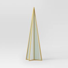 a gold and white triangular shaped object on a plain surface with no people around it