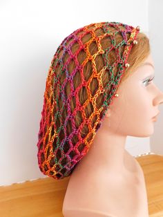 a mannequin head wearing a multicolored crochet knitted hat