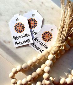 two wooden beads are sitting next to each other on a white surface with an orange flower