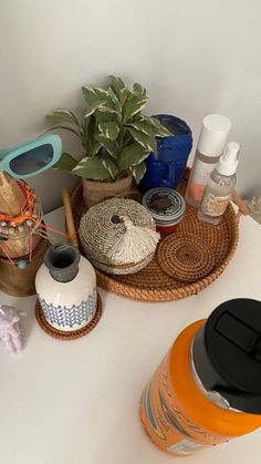 various items are sitting on a table near a potted plant and other things in baskets