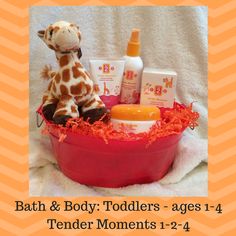 a giraffe stuffed animal sitting in a bath tub with baby products on it