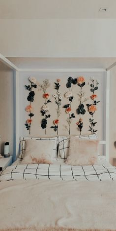 a bed with flowers on the wall above it