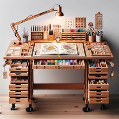 a wooden desk with lots of crafting supplies on top of it and a lamp above