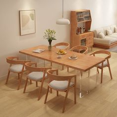 a dining room table and chairs in front of a couch