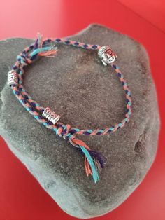 Braided cotton bracelet with Buddha head and silver metal amulets.  Its size is adjustable from 15 to 23 cm. Tibetan Buddha, Lucky Charm Bracelet, Keychain Ideas, Cotton Bracelet, Buddha Head, Amulets, Braided Bracelets, Lucky Charm, Friendship Bracelets