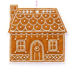 a gingerbread house ornament on a white background