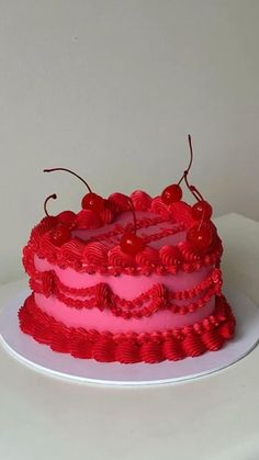 a red and pink cake with cherries on top