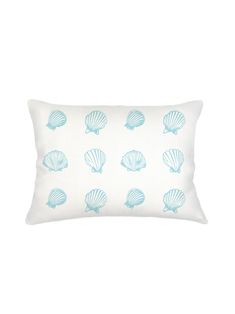 a blue and white pillow with seashells printed on the front, sitting on a white background