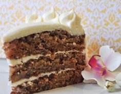 a piece of cake sitting on top of a white plate next to a pink flower