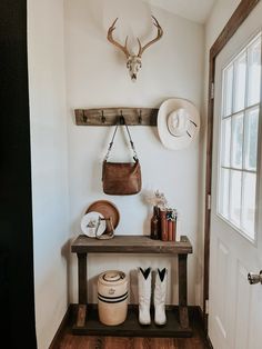 the entryway is clean and organized with hats, boots, and purses on display