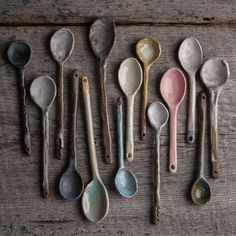 old spoons lined up on a wooden table