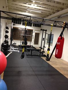 an empty gym with exercise equipment and red balls on the floor in front of it