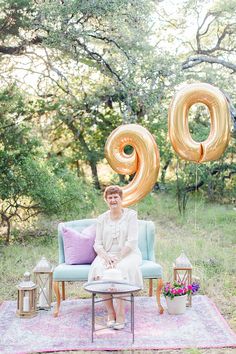 an older woman sitting on a couch with balloons in the shape of o's