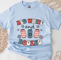 red, white and boozed t - shirt sitting on top of a doily