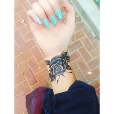 a woman's wrist with tattoos on it and a rose tattooed on the wrist