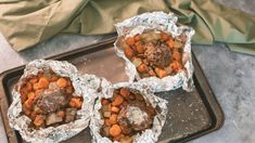 three wrapped up food items sitting on top of a pan