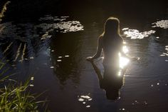 a woman sitting in the water at night