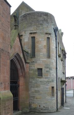 an old brick building with a gate in front of it