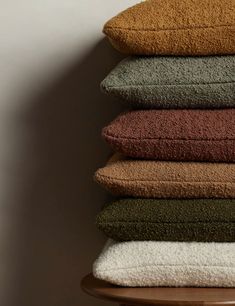 a stack of towels sitting on top of a wooden shelf