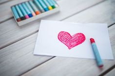 valentine's crafts for kids with crayons and colored pencils on the table