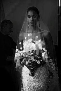 a woman in a wedding dress with flowers on her veil