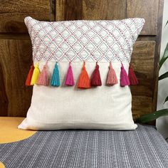 a white pillow with colorful tassels on it