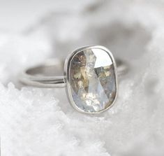 a white diamond ring sitting on top of snow