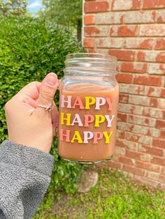 a person holding a jar with the words happy on it