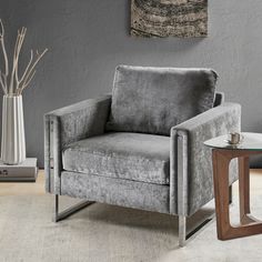 a gray chair sitting next to a glass table