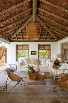 a living room filled with furniture and lots of wood beams on top of the ceiling